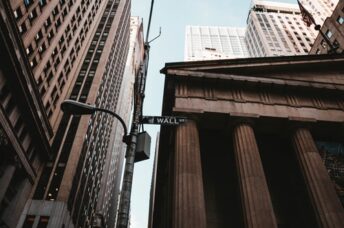 Low angle shot of wall street sign in NYC with buildings around